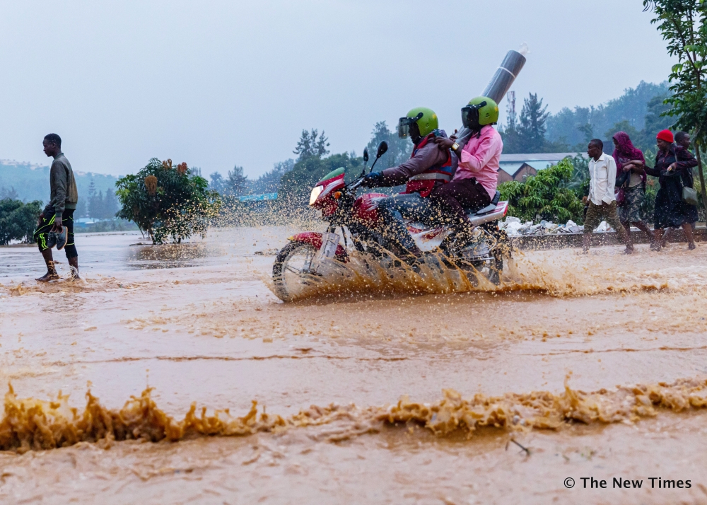 Residents wade through a flooded street in Kigali on January 28, 2020. Rwanda has secured US$310 million loan from IMF’s Resilience and Sustainability Facility to tackle climate change.