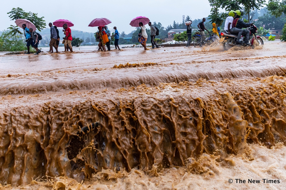 Residents wade through a flooded road at Gakinjiro in Kigali.  File