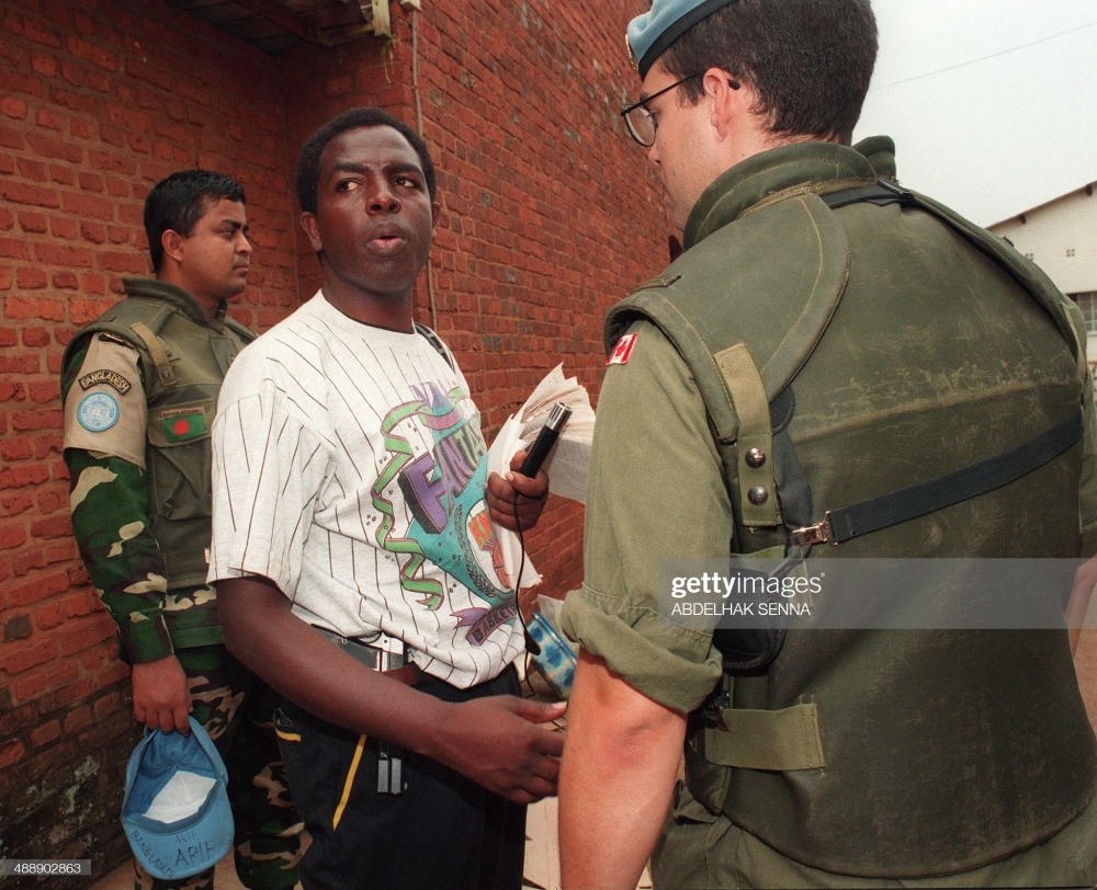 Father Wenceslas Munyeshyaka holding a gun during the Genocide against the Tutsi. He is one of the key masterminds of the Genocide. Getty Images