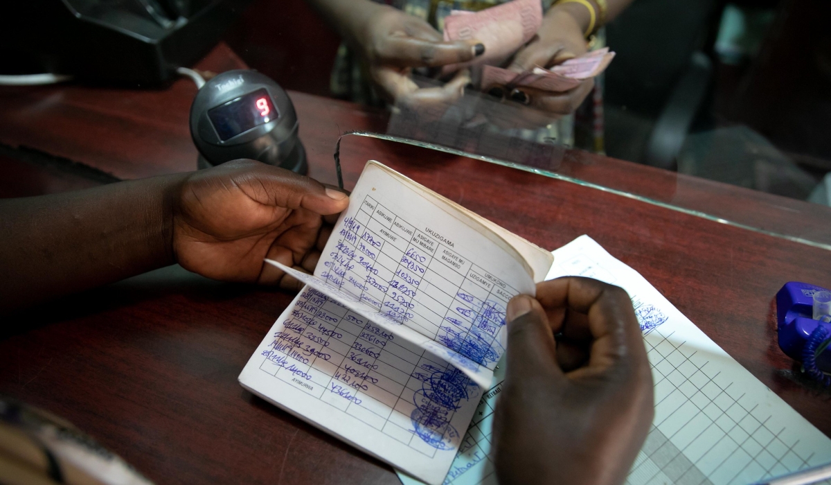 A teller serves a customer at Kacyiru SACCO in Kigali. Craish Bahizi