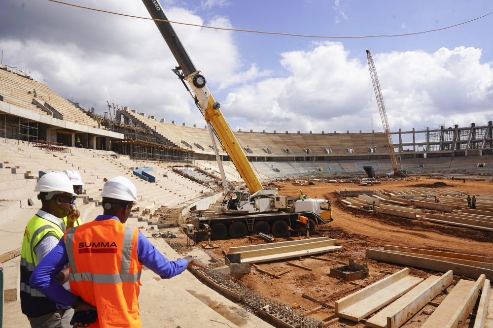 A gigantic mobile crane lifting and placing prefabricated concrete slabs inside the stadium. Photos by Emmanuel Dushimimana and Willy Mucyo