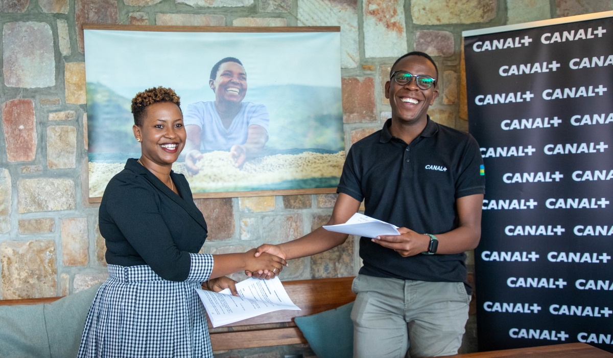 Aimé Abizera, the Sales Director at Canal Plus and Jackie Mutesi, the Executive Director of Kula Project, shake hands after signing the agreement on Friday, June 16. Dan Kwizera