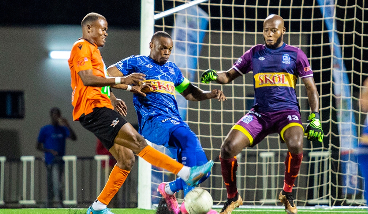 Rayon Sports goalkeeper Bonheur Hategekimana looks so vigilant as defender, team Captain Abdoul Rwatubyaye battles for the ball against Gasogi United striker during 2-1 league game at Kigali Pele Stadium . Courtesy