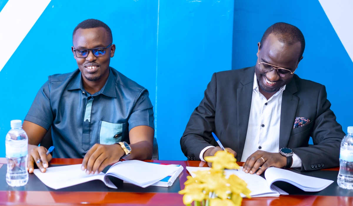 Felix Nkundimana, the CEO of Jali Finance and Frank Mugisha, the former CEO of Koi Pay sign  the agreement in Kigali. Courtesy