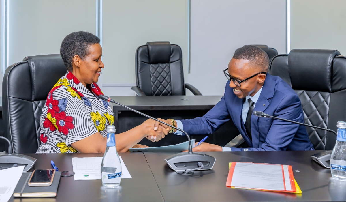 Frank Musinguzi (L) shakes hands with the Chairperson of the National Electoral Commission, Oda Gasinzigwa, after submitting his parliamentary candidature on May 22, 2024, in Kigali (courtesy)