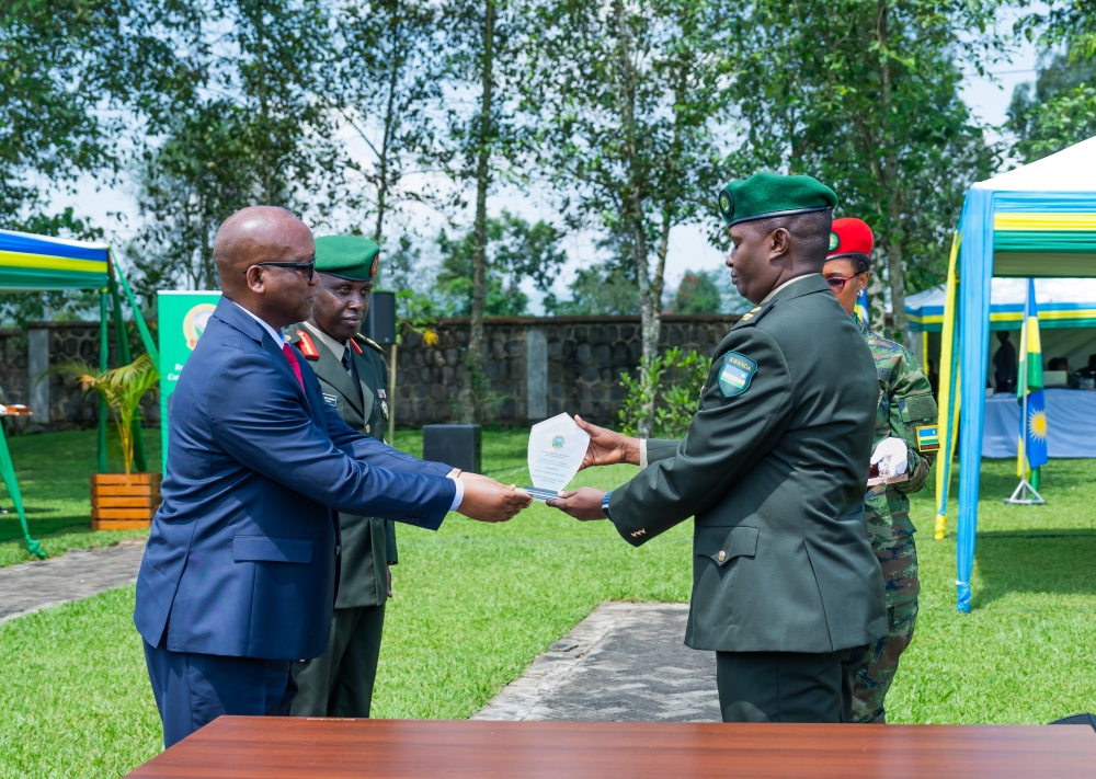 Minister of Defence Juvenal Marizamunda awards one of the graduates during the graduation ceremony at RDF staff and Senior Command College in Nyakinama, Musanze District on Friday, June 7.  