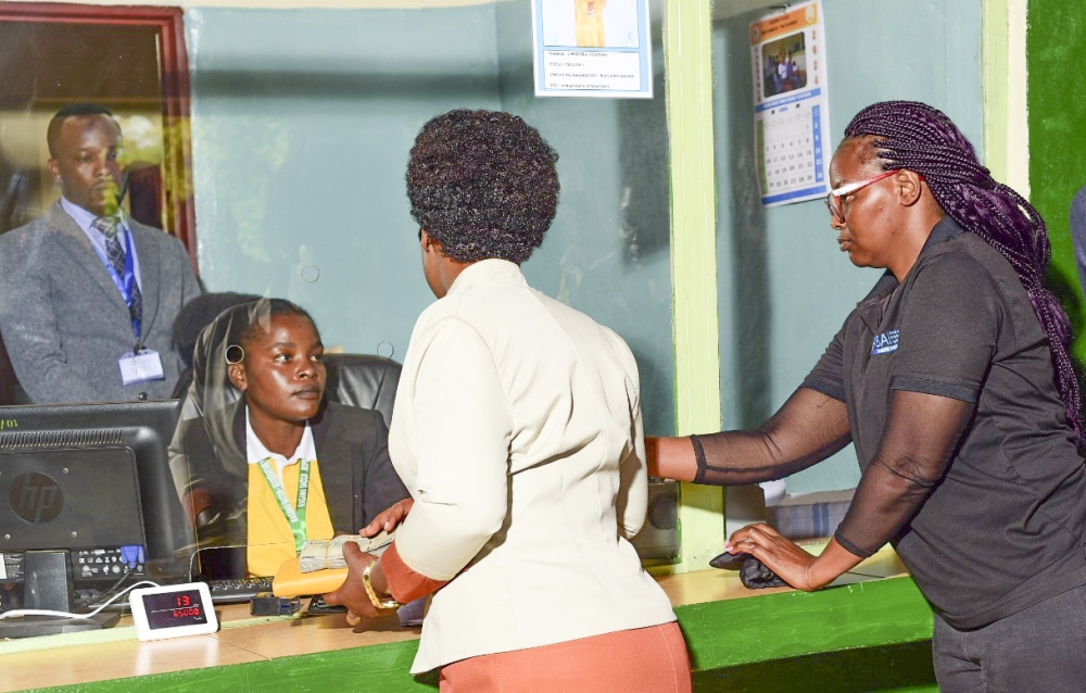 Alphonsine Nyirakamana, a client of  Kagano SACCO in Nyamasheke District, withdraws money from her account  after its automation on Monday,  June 10. Courtesy