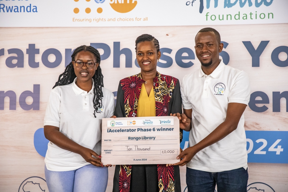 Sandrine Umutoni, the Minister of State for Youth and Arts hands over a cheque to some winners during the awarding event in Kigali on Tuesday, June 11. Each of the six start-ups that emerged top this year was awarded USD $10,000 to scale up their work. Courtesy