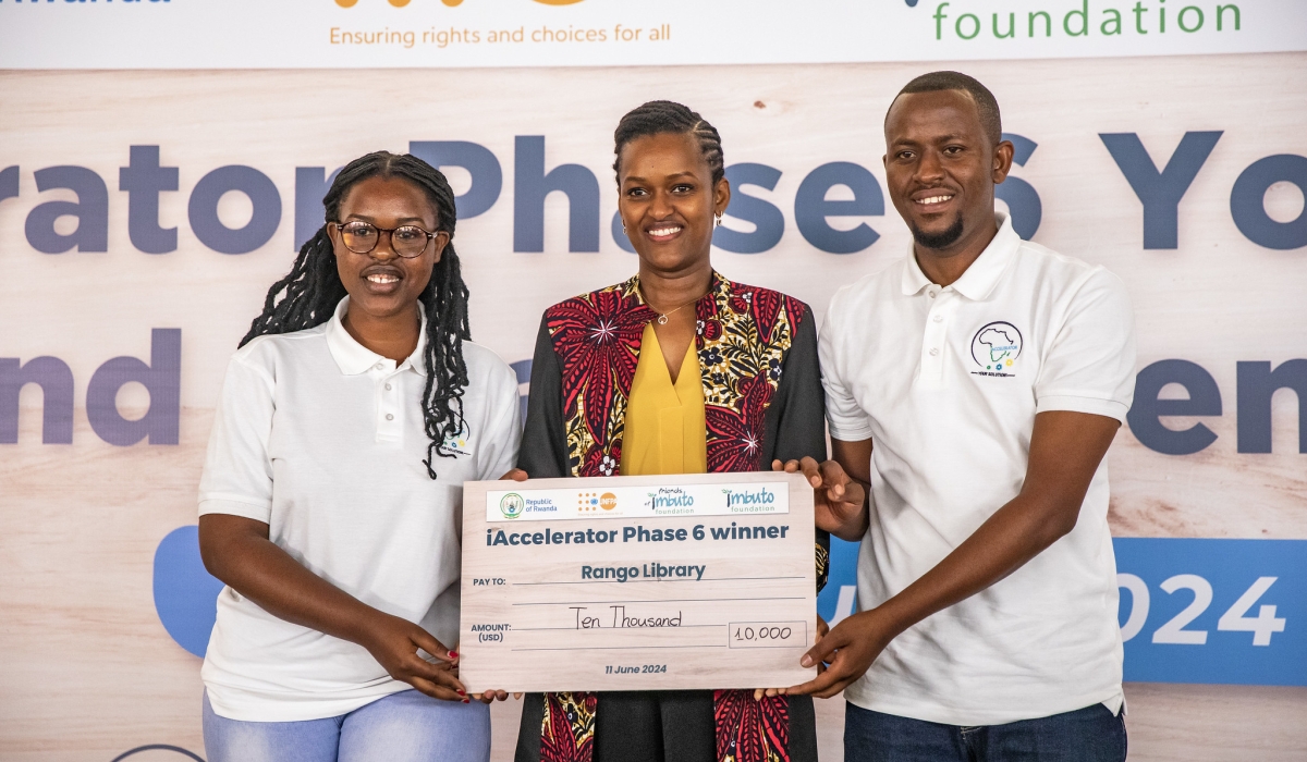 Sandrine Umutoni, the Minister of State for Youth and Arts hands over a cheque to some winners during the awarding event in Kigali on Tuesday, June 11. Each of the six start-ups that emerged top this year was awarded USD $10,000 to scale up their work. Courtesy