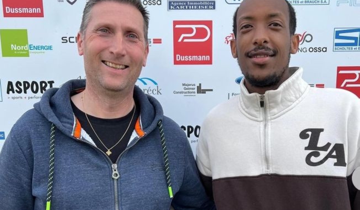 Rwandan midfielder Sven Kalisa poses with an official of Etzella Ettelbruck after signing his new contract.