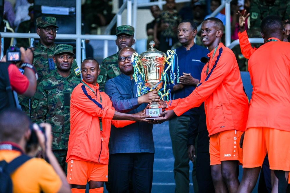 Minister of Defence Juvenal Marizamunda hands over the trophy to the captain after winning the game.