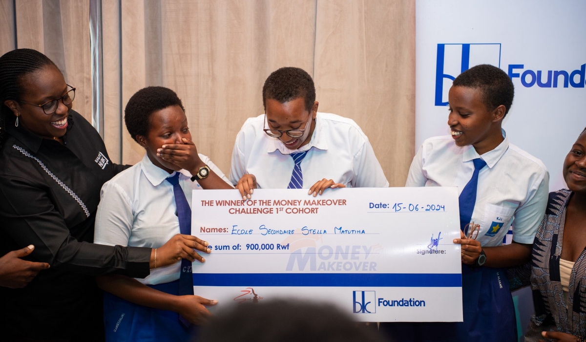 Beata Uwamaliza Habyarimana, CEO of BK Group Plc (L) hands over a cheque to the overall winners Stella Matutina Secondary School at the event at Norrsken on Saturday, June 15.