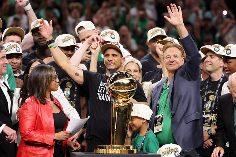 Celtics&#039; coach Joe Mazulla (C) celebrates with the trophy.