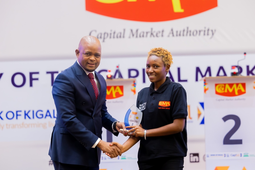 Thapelo Tsheole, chief executive of CMA, presents a trophy to Esther Ashimwe, the first runner-up in the 2024 Capital Market University Challenge at the national level.