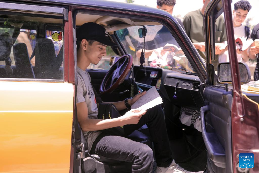 People read books at a mobile taxi library in Alexandria, Egypt, June 29, 2024. (Xinhua/Ahmed Gomaa)