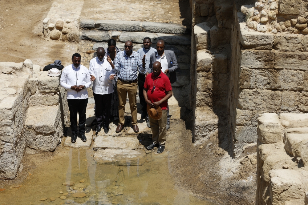 Rwandan priests say a prayer at the spot where it is claimed that Jesus was baptised.