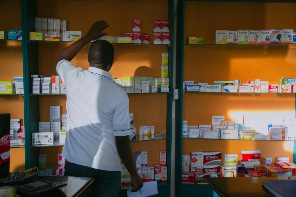 A pharmacist searching medicaments in a pharmacy in Kigali. Photo by Craish Bahizi