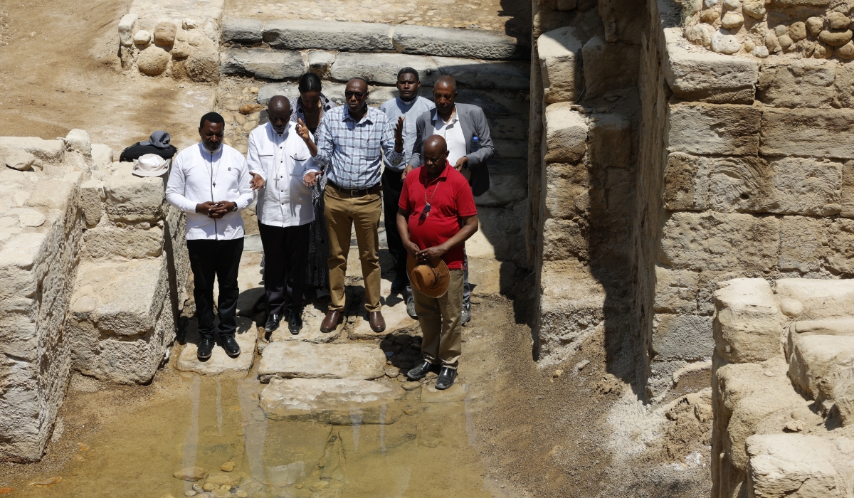 Rwandan priests say a prayer at the spot where it is claimed that Jesus was baptised.