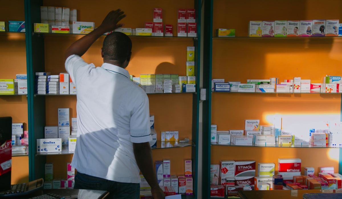 A pharmacist searching medicaments in a pharmacy in Kigali. Photo by Craish Bahizi