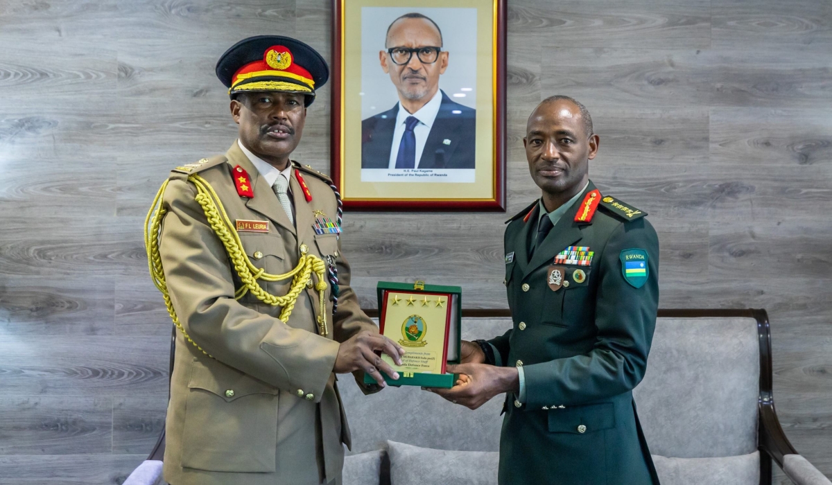 Rwanda Defence Force Chief of Defence Staff Gen Mubarakh Muganga presents a gift to Maj Gen Frederick Leuria, the Assistant Chief of Defence Force for operations, planning, doctrine and training of the Kenyan Defence Forces (KDF), in Kigali, on Friday, July 5.