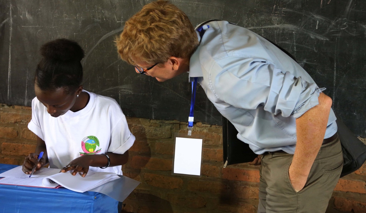 One of the European Union observers checks out what a National Electoral Commission volunteer is doing at the Kimironko II polling site, in Kigali, during the parliamentary elections on September 3, 2018. Photo by  Sam Ngendahimana