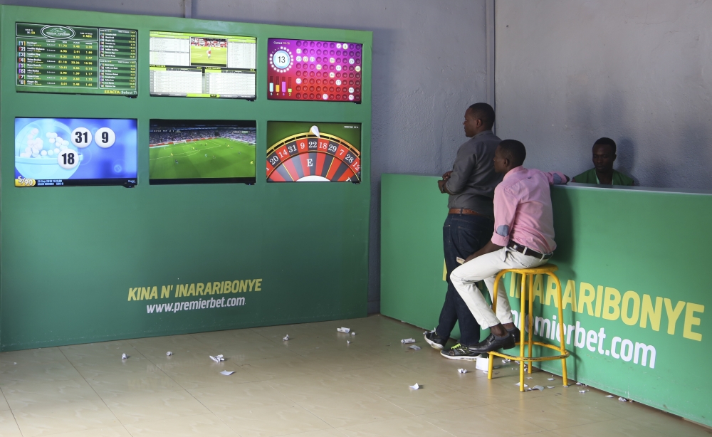 Clients follow a football match at Premier Bet branch in Kigali. Craish Bahizi