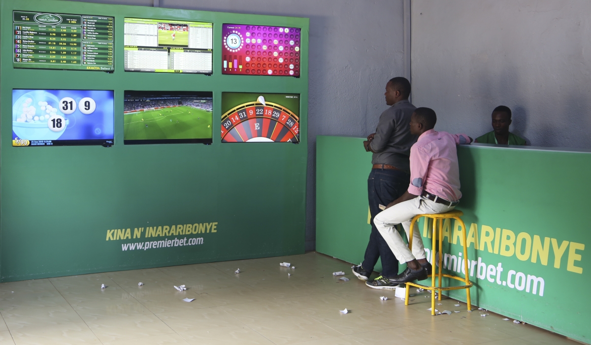 Clients follow a football match at Premier Bet branch in Kigali. Craish Bahizi