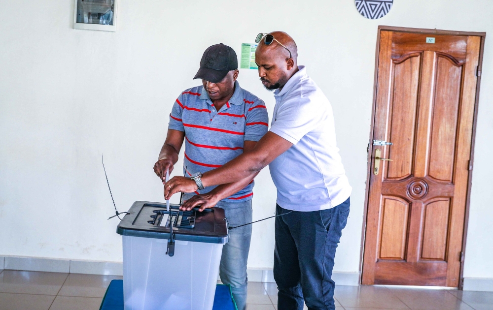 A voter is assisted to put his ballot paper in the box after casting his vote to choose MPs  represent persons with disabilities in the Chamber of Deputies.