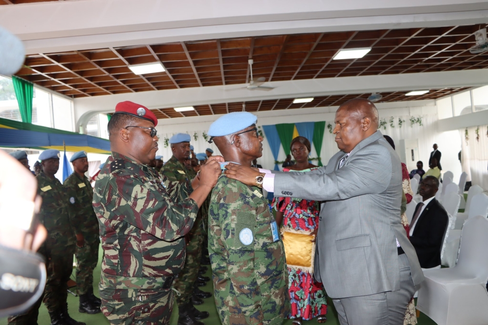 The Chief of General Staff of the Central African Republic Armed Forces, Maj Gen Zéphirin Mamadou (R), and his Commander-in-Chief President Faustin Archange Touadera (L), award a Rwandan peacekeeper serving under the United Nations Multidimensional Integrated Stabilization Mission in the country (MINUSCA), on July 16, with the Presidential Medal. Courtesy