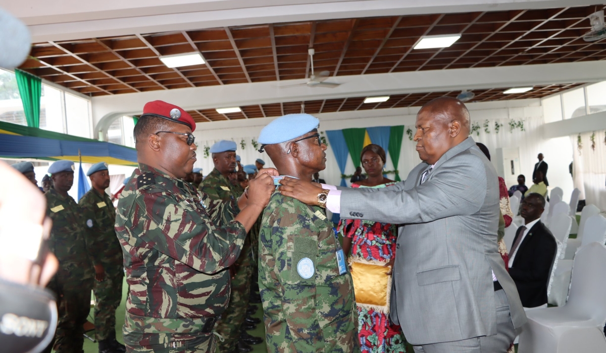 The Chief of General Staff of the Central African Republic Armed Forces, Maj Gen Zéphirin Mamadou (R), and his Commander-in-Chief President Faustin Archange Touadera (L), award a Rwandan peacekeeper serving under the United Nations Multidimensional Integrated Stabilization Mission in the country (MINUSCA), on July 16, with the Presidential Medal. Courtesy