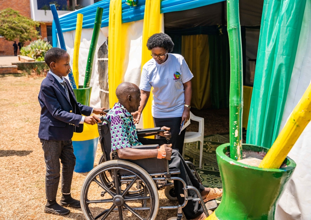A child assisting a patient to enter a polling room set at CHUK hospital to facilitate patients and medics to cast their votes on Monday, July 15. Photo by Craish Bahizi