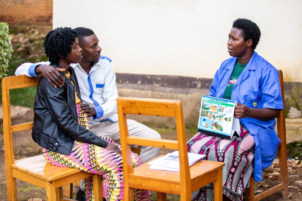 A community health worker interacts with a pregnant woman with her husband at Mubuga Hospital in Karongi District on December 9, 2022. Photo by Olivier Mugwiza
