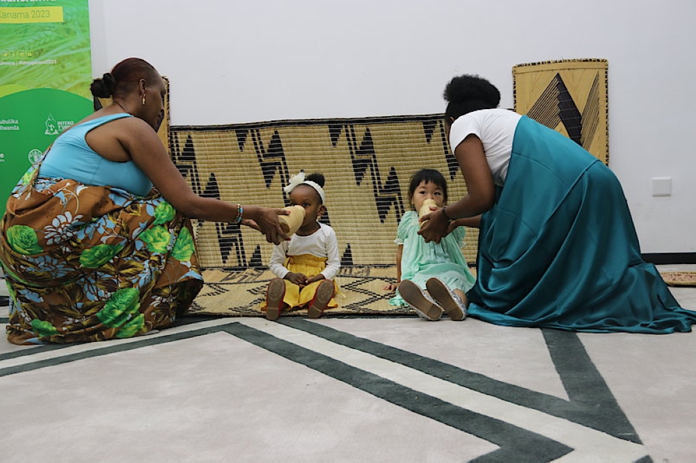 Children drink milk from traditional containers (Inkongoro) during the Umuganura celebration in China