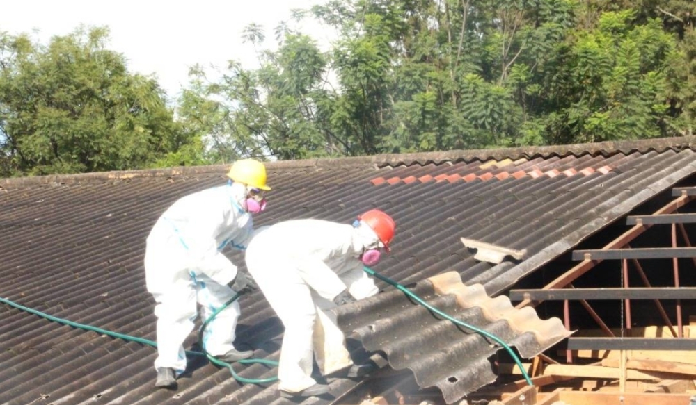 Workers remove asbestos on one of buildings of the University of Rwanda in Huye. Courtesy