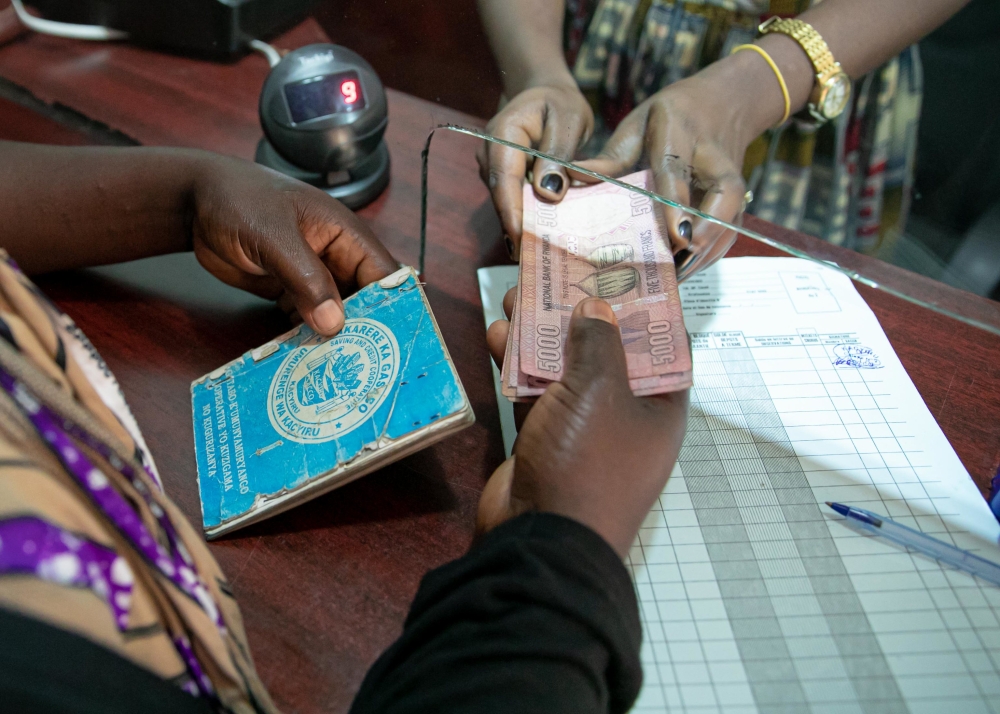 SACCO teller serves a customer at Kacyiru SACCO.SACCOs in the three districts of Kigali and Gicumbi District in Northern Province will be consolidated into District SACCOs (D-SACCOs) by the end of December.