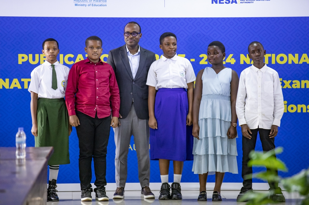 Minister of Education Gaspard Twagirayezu poses for  a photo with top performers in PLE during the launch of the results in Kigali  on Tuesday, August 27. The results of the Primary Leaving Exams (PLE) indicate that girls outperformed boys, with a pass rate of 97 per cent compared to 96. Photos by Emmanuel Dushimimana