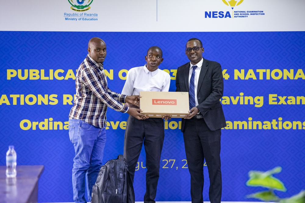 Jean de Dieu Niyonzima, one of best performers in O-Level national exams, receives a Lenovo laptop during the release of the results on Monday, August 27.