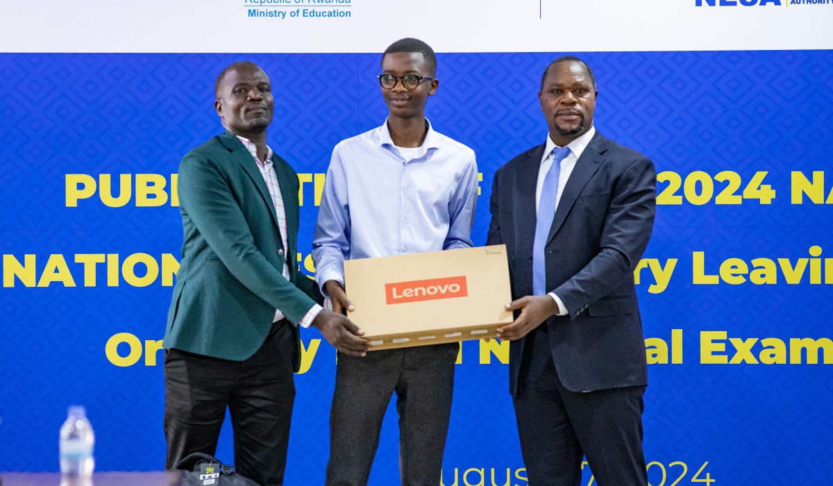 Denys Prince Tuyisenge and his father Denis Nzabonariba (left) receive a laptop as an award from Bernard Bahati, the Director General of National Examination and School Inspection Authority on Tuesday, August 27. Photo by Emmanuel Dushimimana