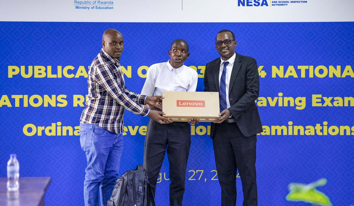 Jean de Dieu Niyonzima, one of best performers in O-Level national exams, receives a Lenovo laptop during the release of the results on Monday, August 27.