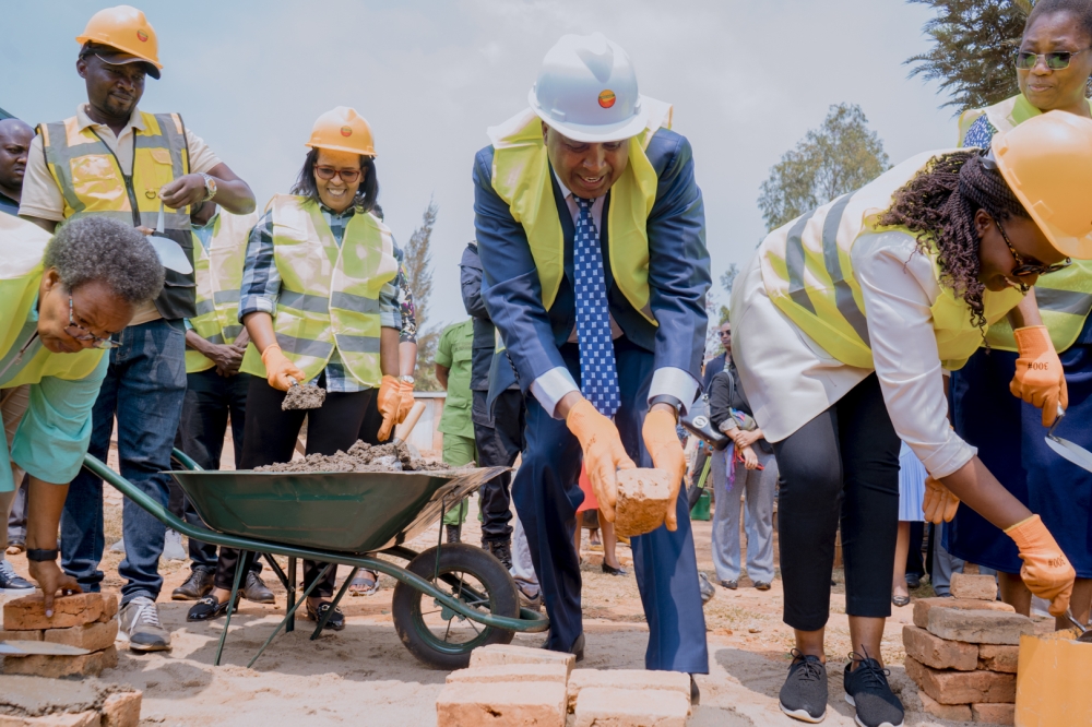 Imbuto Foundation Director General, Elodie Shamie (right), Mount Kigali University founder and chairman, Prof. Simon Gicharu, and staff from Imbuto Foundation and Mount Kigali University prepare to lay bricks during the groundbreaking event.