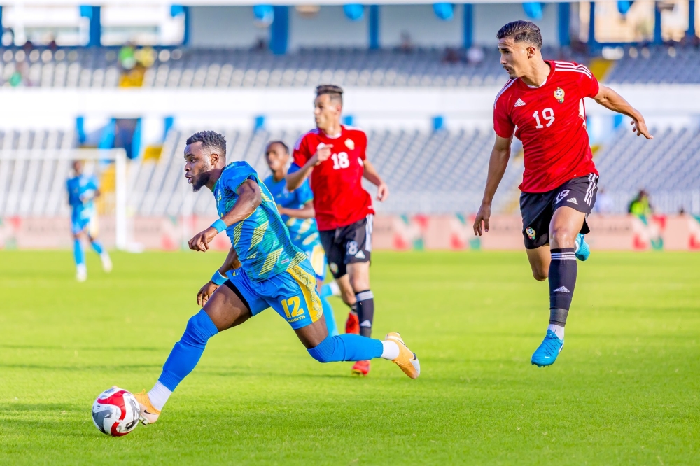 Amavubi forward Gilbert Mugisha wins the ball against Libya players during the game.