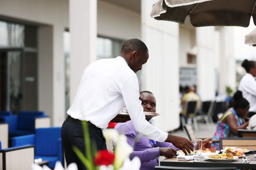 A waiter serves a customer in Kigali.  (Sam Ngendahimana)