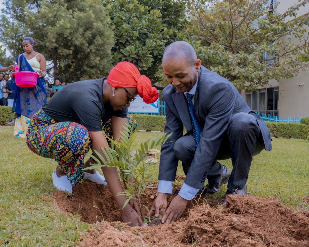 Dr Martin Kimemia assists Charlene Ruto in planting a tree at the university.
