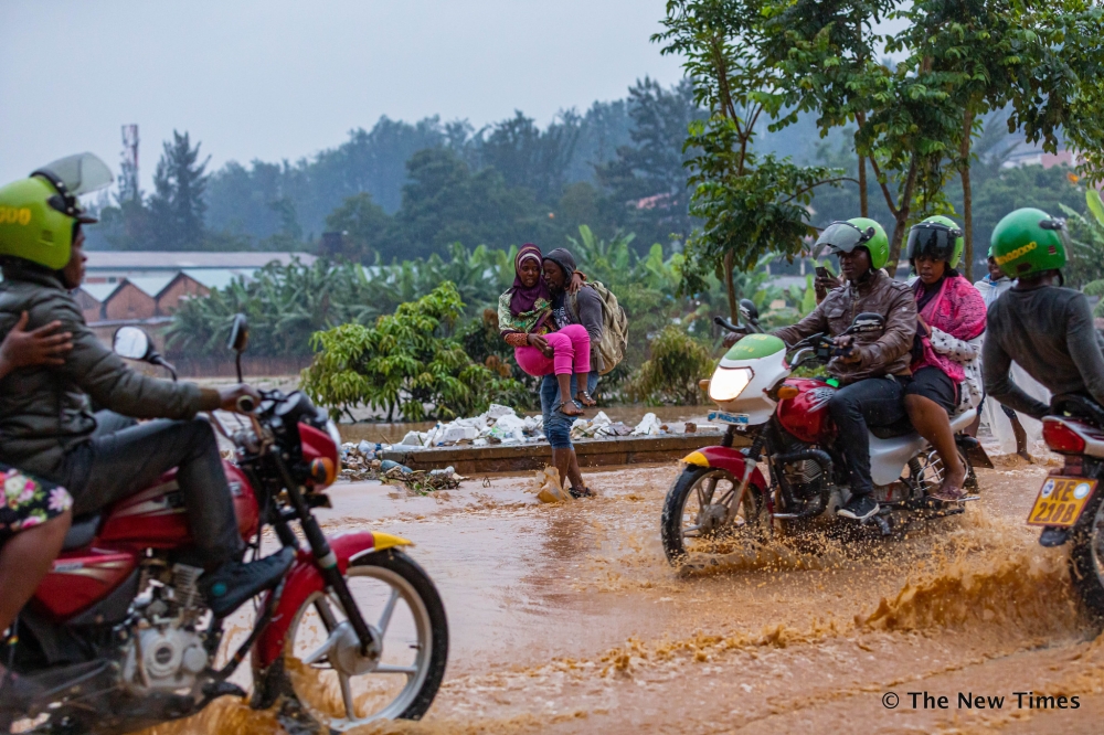 Road users wade through a flooded street  after heavy rains in Kigali on January 28, 2020. Rwanda has its sights set on the next round of global climate talks at the upcoming COP29, which will take place in Azerbaijan in November. File