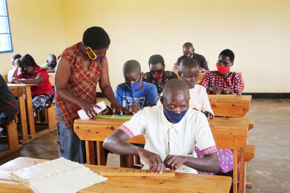 A teacher helps people with disabilities who are visually impaired students at Masaka in Kigali. Craish Bahizi