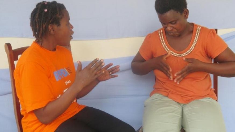 Two ladies during interact through sign language in Muhanga District. The government is distributing the first-ever comprehensive Rwandan Sign Language Dictionary (RSLD).