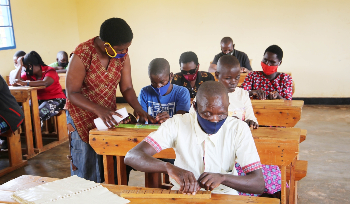 A teacher helps people with disabilities who are visually impaired students at Masaka in Kigali. Craish Bahizi