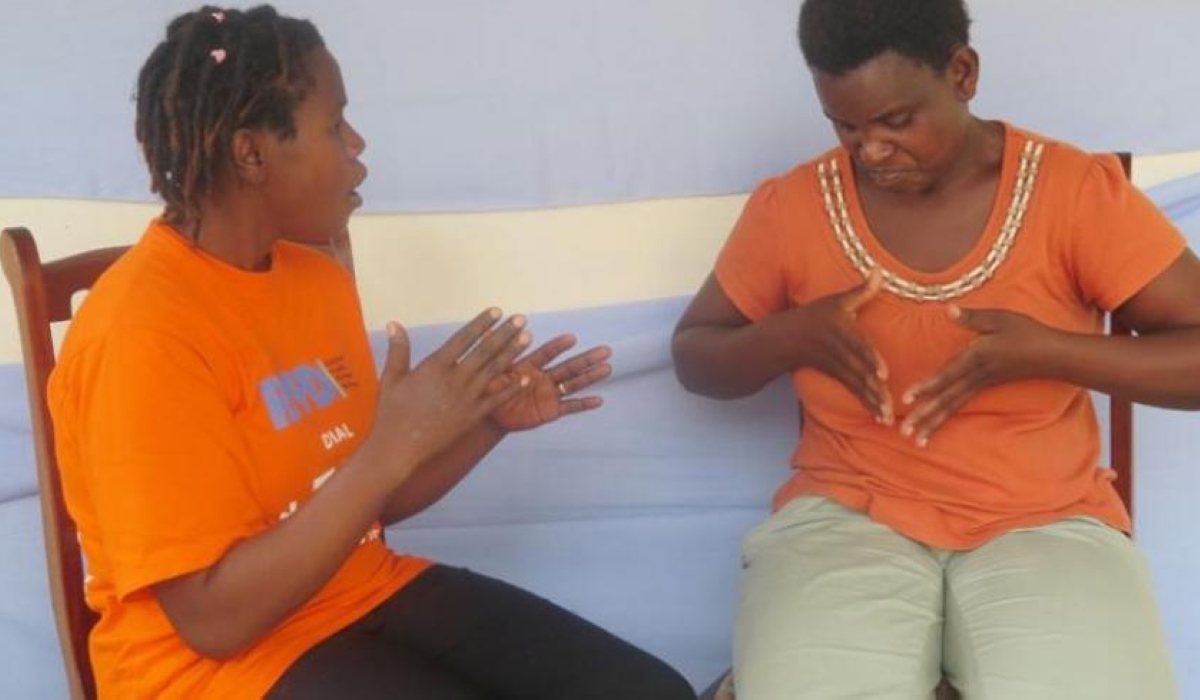 Two ladies during interact through sign language in Muhanga District. The government is distributing the first-ever comprehensive Rwandan Sign Language Dictionary (RSLD).