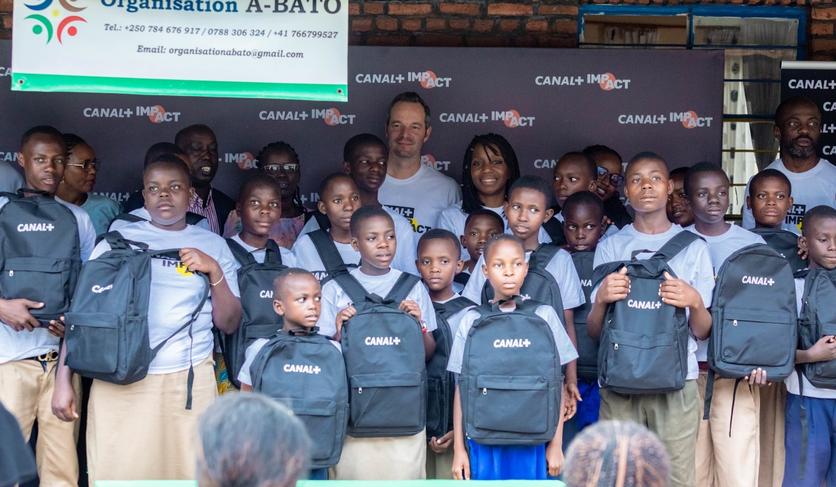 CANAL+ Rwanda officials pose for a photo with beneficiaries as they donated school materials and food items to 28 underprivileged children and their families  on September 26. All photos by Craish Bahizi