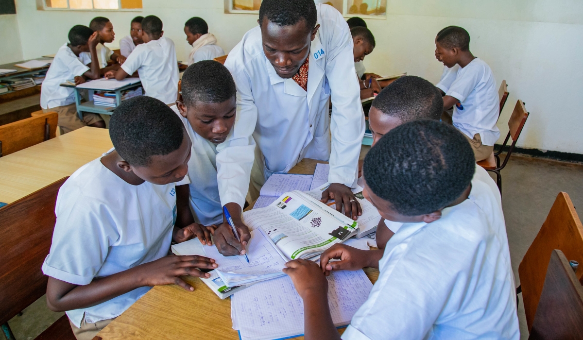 A teacher helps students during group work at Institut Sainte Famille de Nyamasheke. Photo: Courtesy